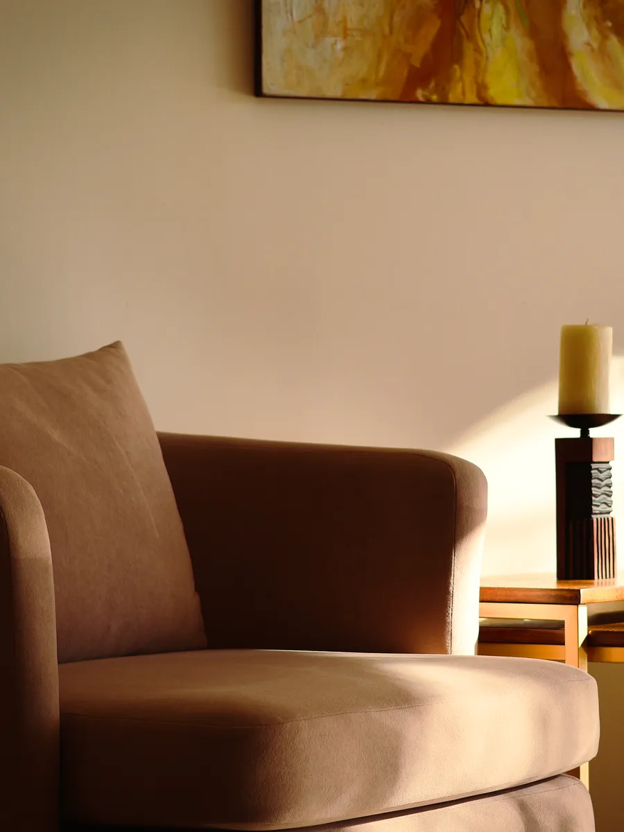 Coin d'attente du centre Les Naturelles, fauteuil et bougie dans la lumière du matin